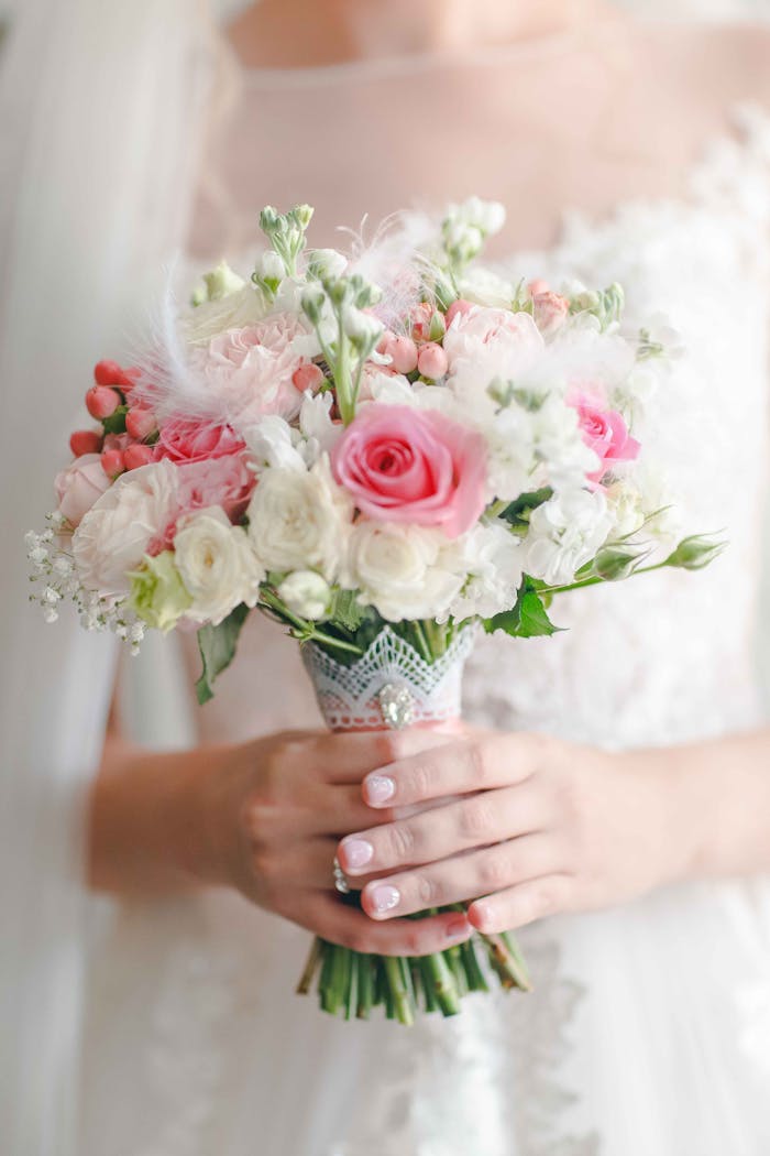 services-04 Soft pastel bouquet held by a bride, featuring roses and delicate florals for a romantic wedding vibe.