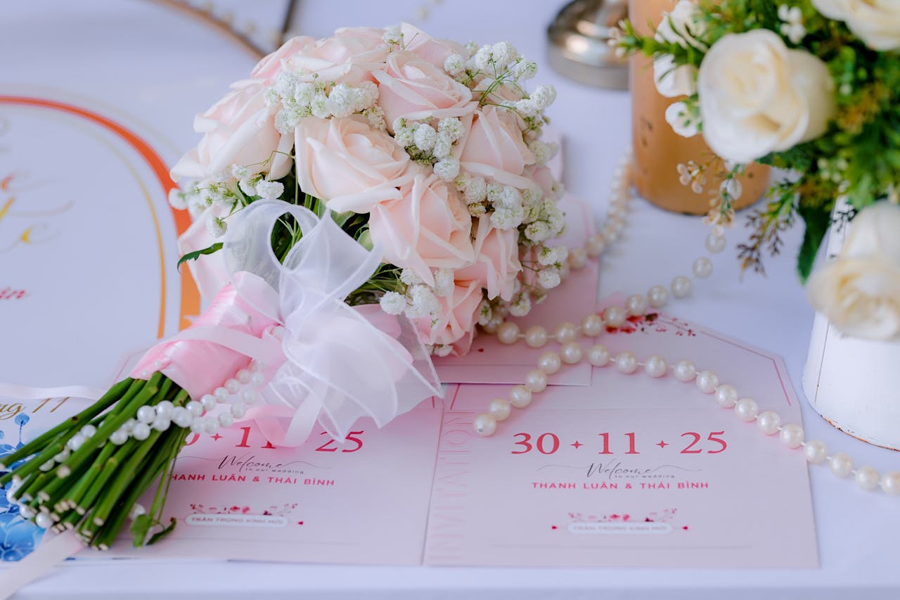 services-02 Delicate pink rose bouquet with wedding invitations on a table, perfect for a romantic wedding setting.